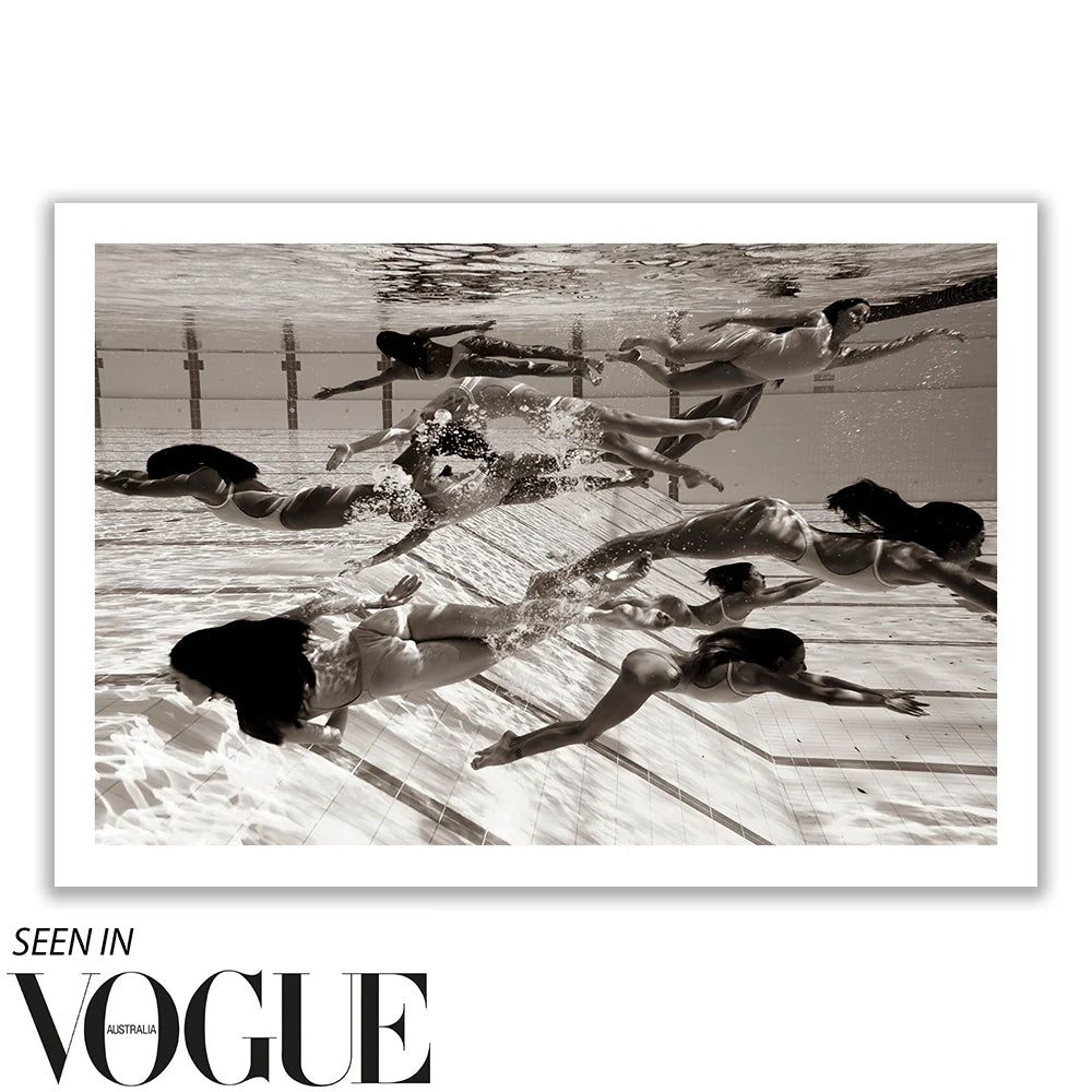 Underwater photo of synchronized swimmers in graceful poses, evoking the elegance of Olympic Artistic Swimming. Their dynamic movements create patterns in black and white, giving a timeless, artistic quality to this fine art print titled "Ladies in Waiting #4" by Francesca Owen. "Seen in Vogue Australia" is noted at the bottom.