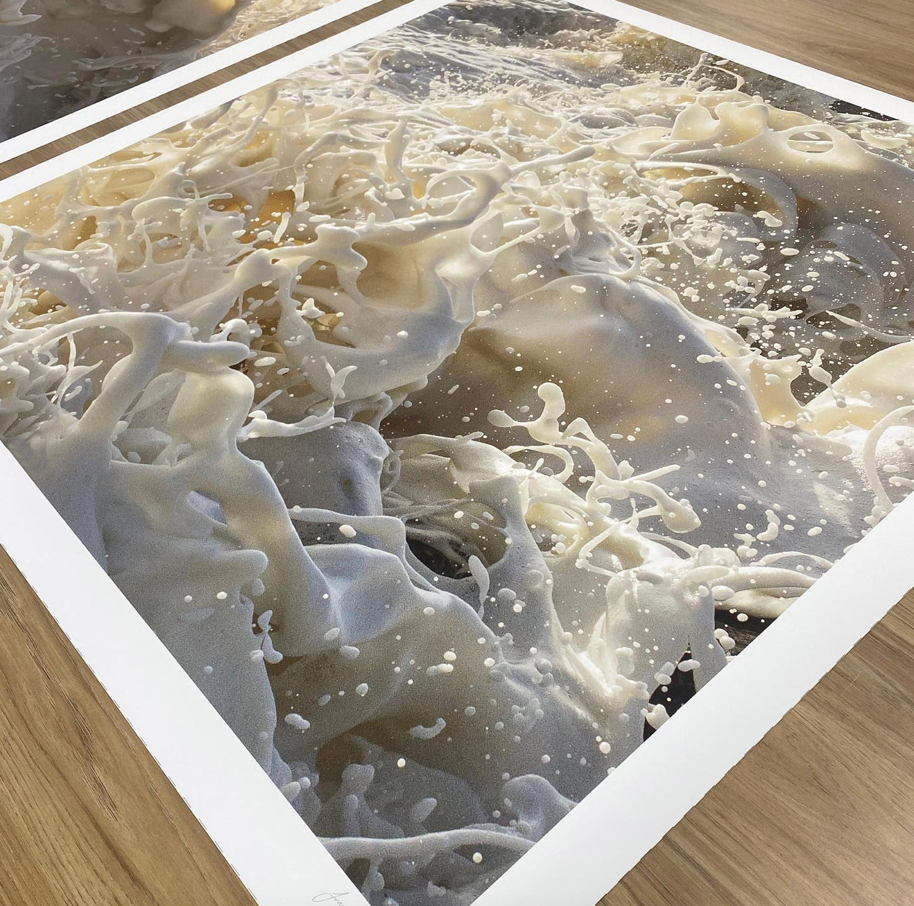 A high-resolution photograph of sea foam captured in mid-motion, with numerous bubbles and frothy waves creating a dynamic and chaotic scene. Presented as "Wild Seas Part I, V 2 — Limited Edition Print" by Francesca Owen, this archival pigment print on fine art paper is displayed beautifully on a wooden surface.