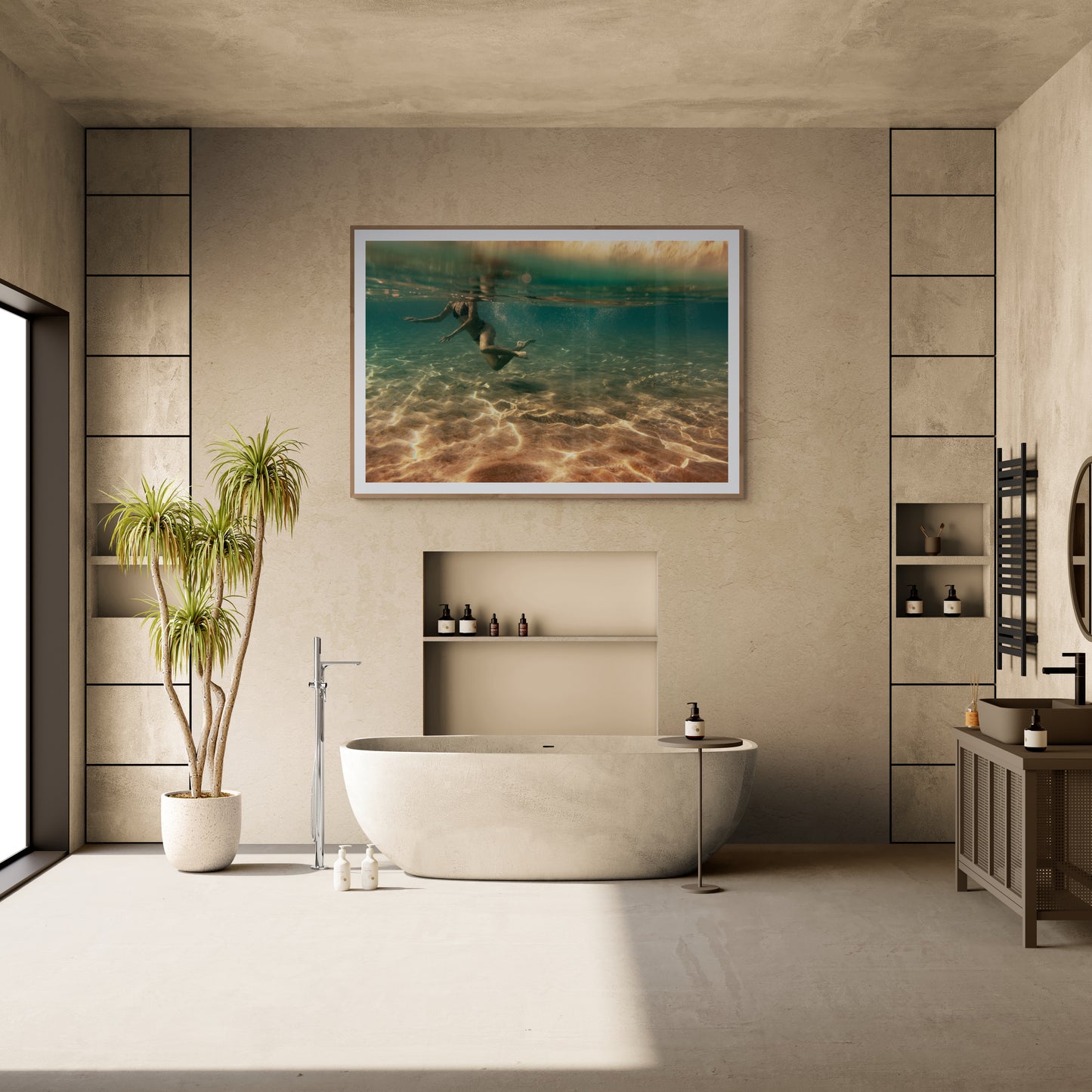 A modern bathroom featuring a freestanding tub, wall niches for toiletries, and a large plant. A rectangular mirror is mounted above the vanity against light-colored stone walls. The space is elegantly enhanced by "Magic in Milos #4," an underwater photo printed on fine art paper using archival pigments from Francesca Owen.